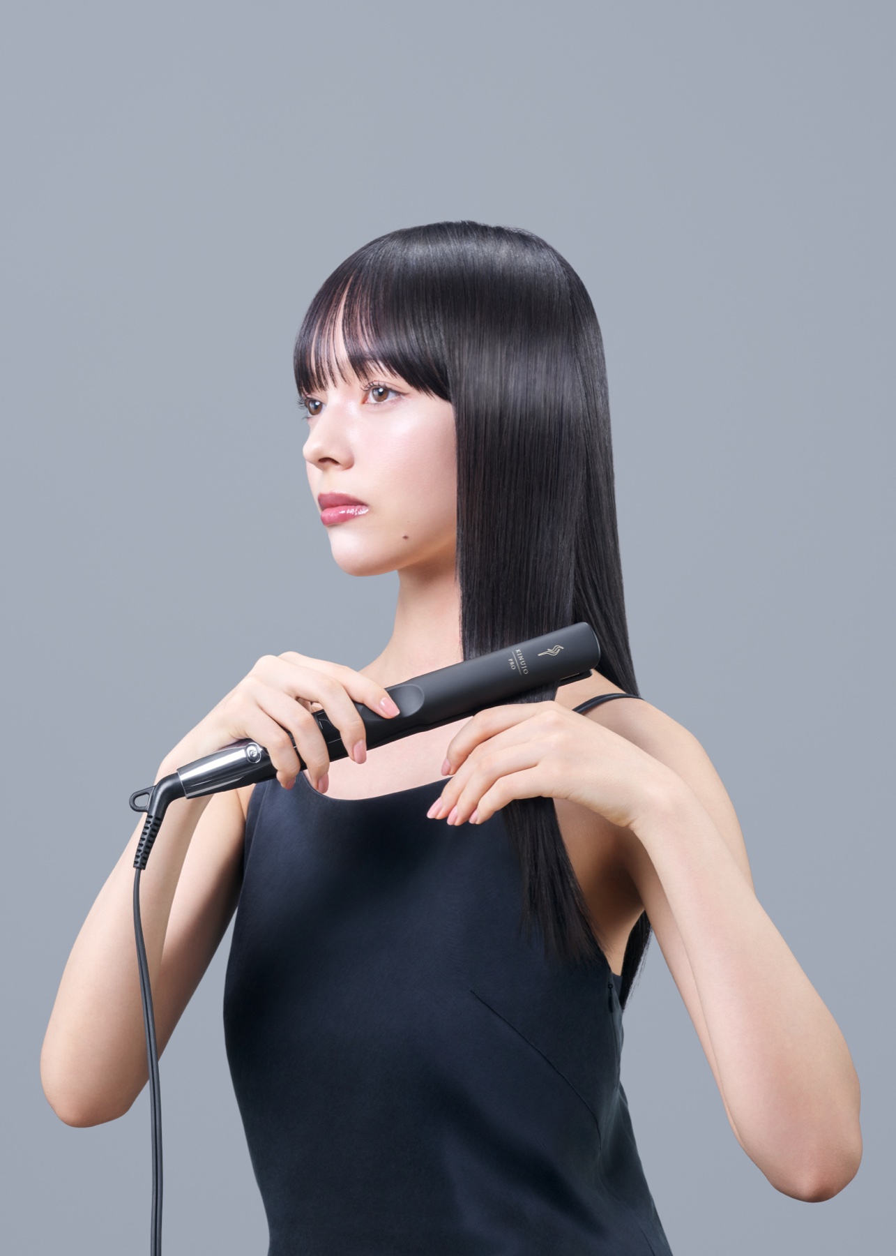 ストレートアイロンでスタイリングしたツヤのあるロングヘアの女性